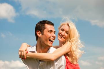 Young love Couple smiling under blue sky