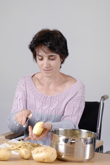 femme handicapé dans chaise roulante préparant le repas