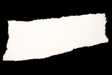 Ripped piece of white torn paper on black background