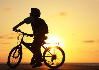 Fototapeta premium Silhouette of teenager riding bicycle