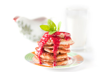 Pancakes with rasberry sauce. Sauceboat with sauce and milk behi