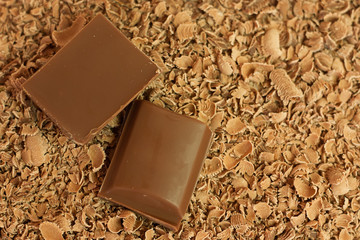 Two chocolate pieces over chocolate shaving