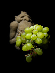A gargoyle offering a bunch of grapes