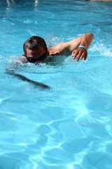 adult latin man swimming in a pool