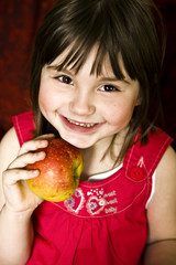 Uśmiechnięta dziewczynka z jabłkiem