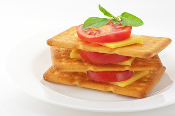 Crackers with cheese, tomato and basil