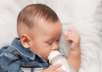 Baby boy holding milk bottle