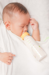 Baby boy holding milk bottle
