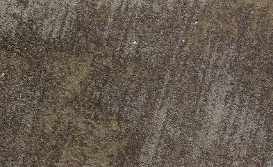 brown gray gravel ground surface seen from top with tracks from