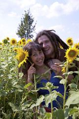 Happy young couple in sunflower field.