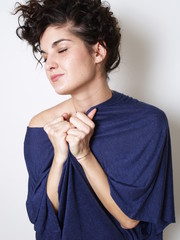 Young woman in blue t-shirt hugging herself