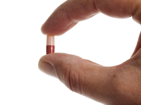 medizin kapsel zwischen zwei fingern gehalten