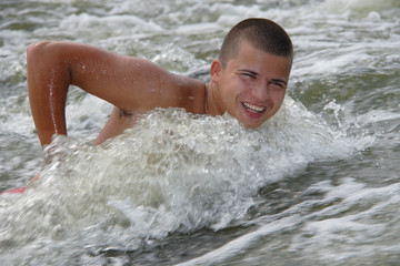 young man swimming against water stream