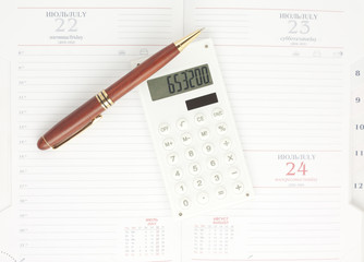 Pen and white calculator on the organizer, top view