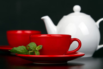 Red cup with mint and white teapot