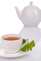 Cup of tea and white teapot