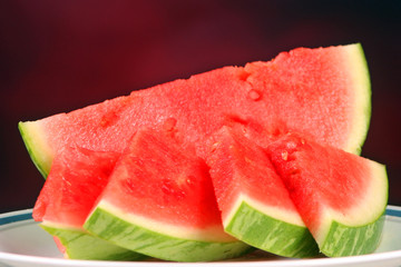 Watermelon slices set against a red background