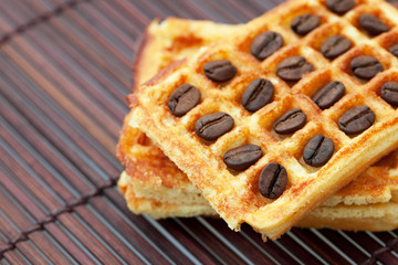 waffles and coffee beans on a bamboo mat