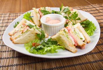 Canape with ham and egg and cup of sauce.