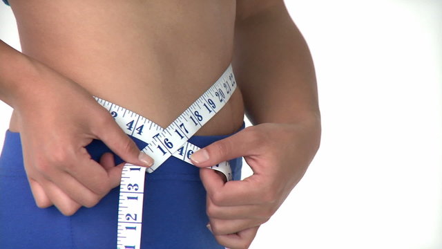 Young beautiful asian woman measuring her waist with a tape meas