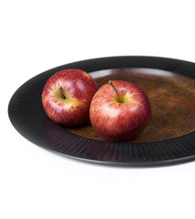 Two red apples on a plate.. Isolated on white background.