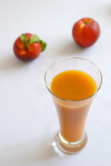 Glass of juice and two peaches