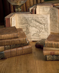 Vintage books and old maps on a wooden table.
