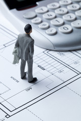 concept homme d'affaires miniature plan et calculs