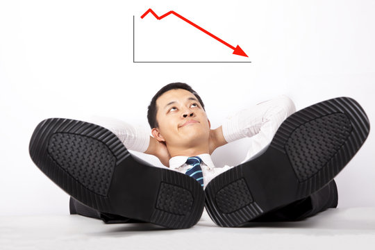 Helpless young businessmen looking at the profit graph