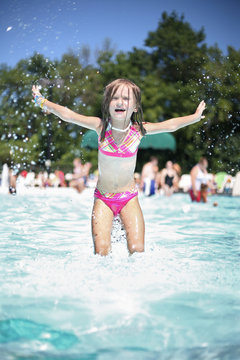 Girl enjoys summer day at the swimming pool.