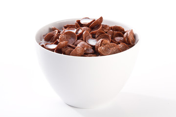 Bowl with corn flakes and milk on the white background