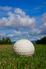 Golfball on course and blue sky