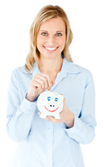 Fototapeta na wymiar Smiling businesswoman saving money in a piggy-bank