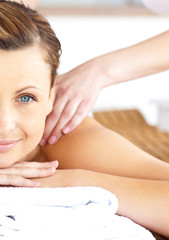Close-up of a beautiful woman receiving a back massage looking a