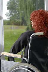 Femme handicapé dans chaise roulante regardant le jardin