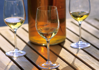 glasses of white wine with a bottle on a wooden table