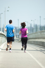 Young people jogging on bridge