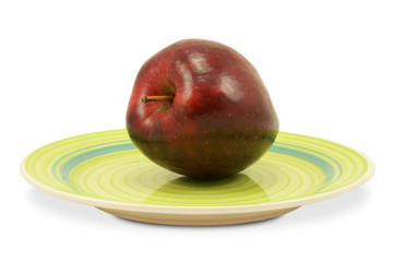 green plate with red apple on white background
