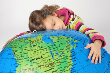 girl lies on big inflatable globe and embracing it, eyes closed