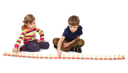 little boy and girl playing with wooden railway sitting on floor