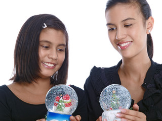 smiling girls shaking the christmas snow globe