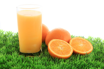 Orange juice and fruit on grass