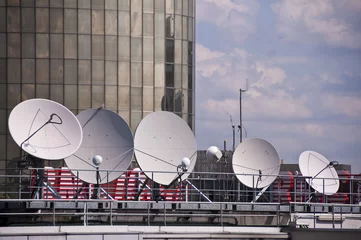 Foto auf Alu-Dibond Plusieurs antennes paraboliques sur le toit d'un immeuble © Delphotostock