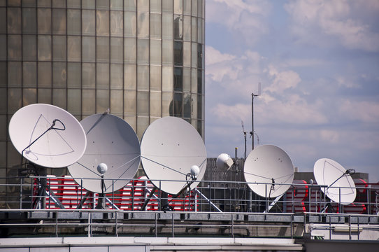 Plusieurs antennes paraboliques sur le toit d'un immeuble