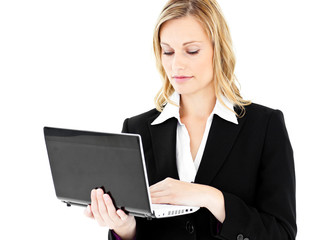Self-assured businesswoman using her laptop standing