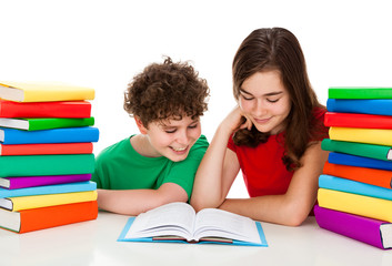 Girl and boy between piles of book isolated on white