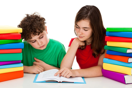 Girl And Boy Between Piles Of Book Isolated On White