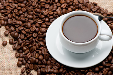 Cup of coffee on coffee grains