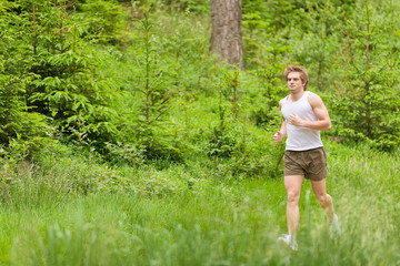 Obraz na płótnie Canvas Morning run: Young man jogging in nature