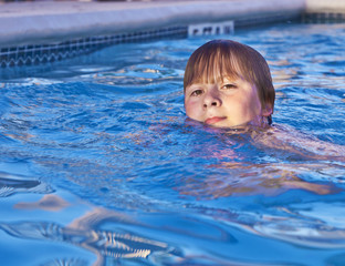 Fototapeta na wymiar child has fun in the outdoor pool